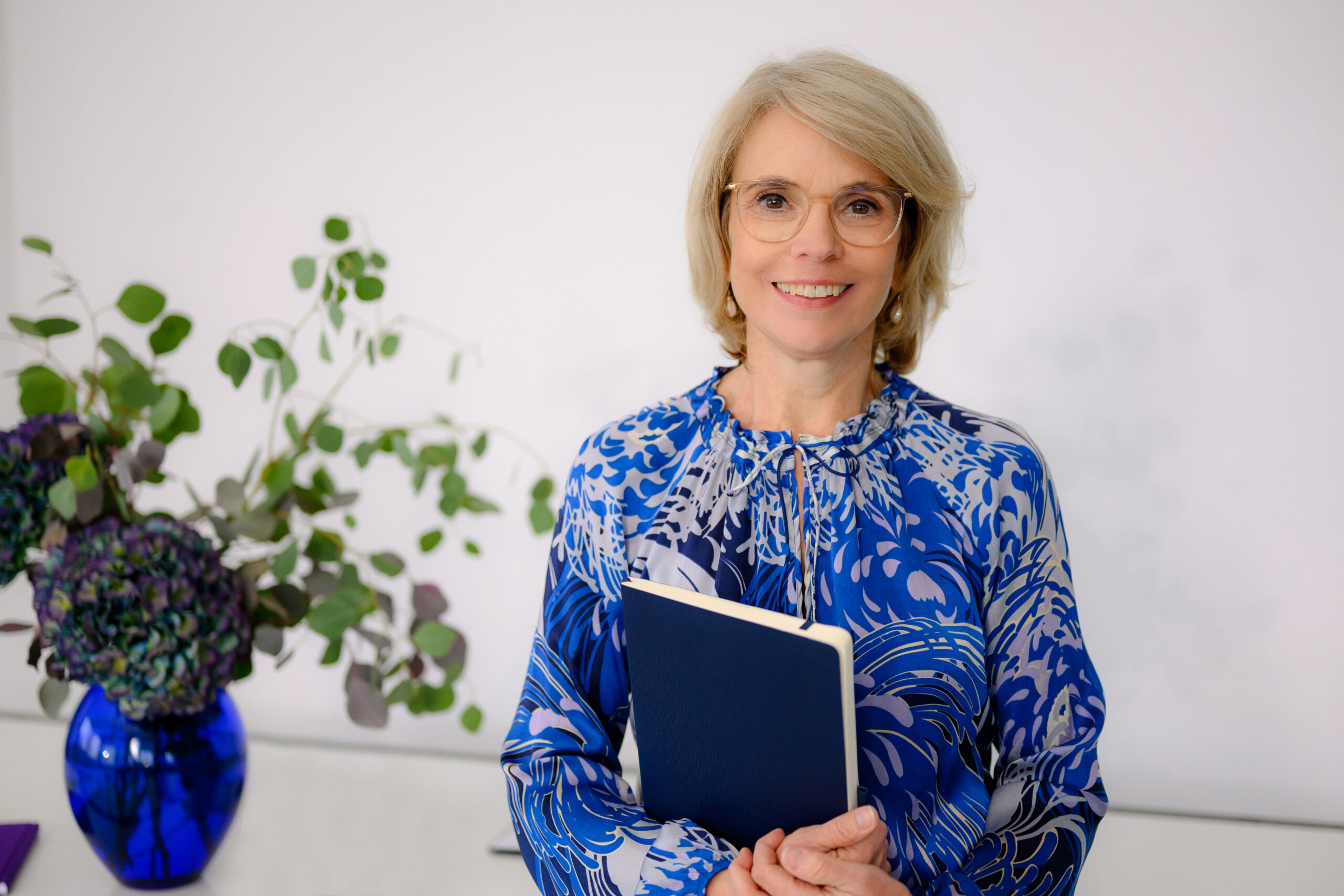 Verena Schiffer Personalberaterin aus München steht im Büro mit Stellenangebots-Mappe in der Hand